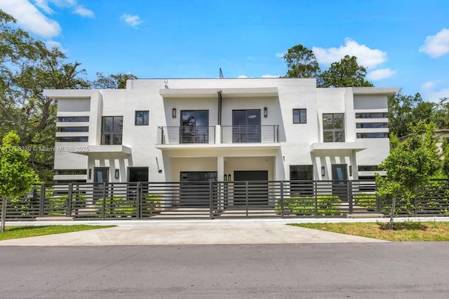3224 Elizabeth St Unit 3224, Miami, FL 33133 - contemporary house with a balcony, driveway, stucco siding, fence, and a carport