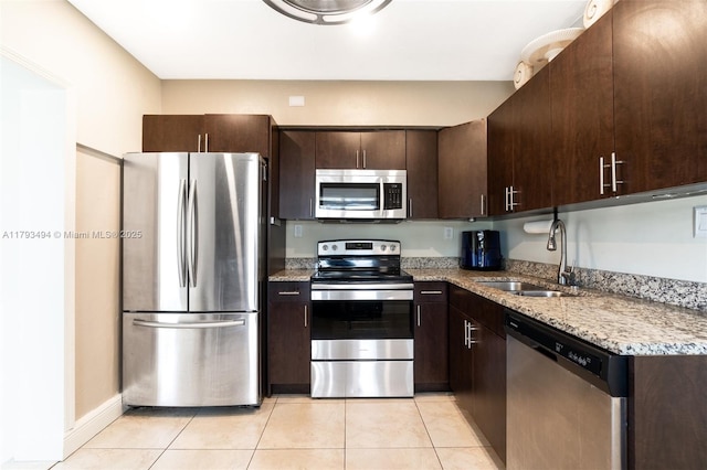 327 S 28th Ave, Hollywood, FL 33020 - kitchen with appliances with stainless steel finishes, a sink, dark brown cabinets, light tile patterned floors, and light stone countertops