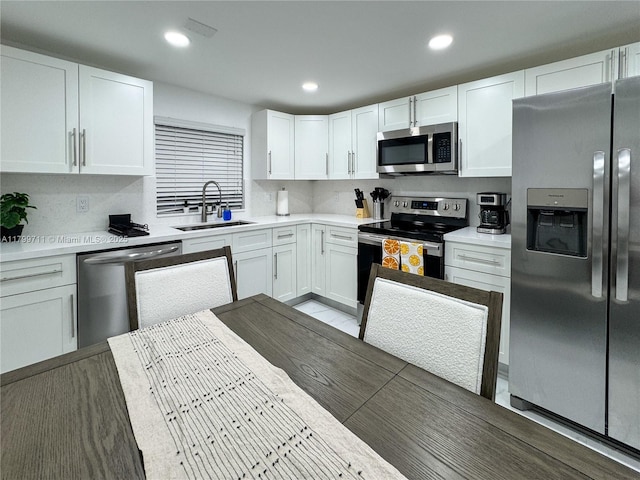 2966 NW 26th St, Miami, FL 33142 - kitchen featuring appliances with stainless steel finishes, a sink, light countertops, white cabinets, and recessed lighting