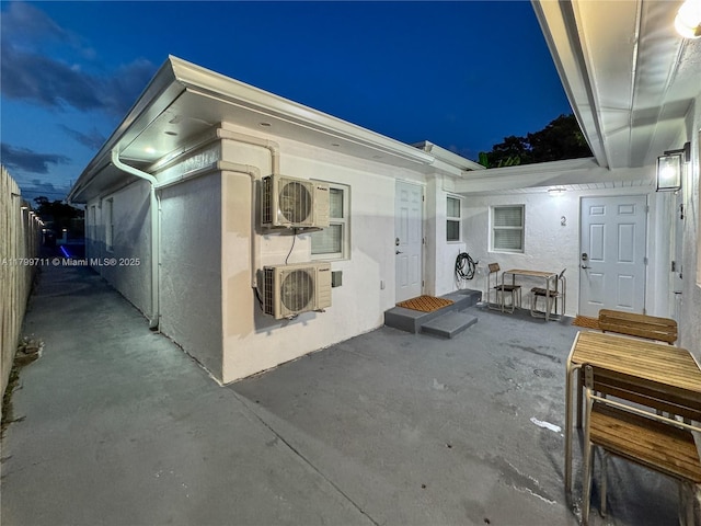 2966 NW 26th St, Miami, FL 33142 - back of house at night with a patio, ac unit, outdoor dining space, and fence