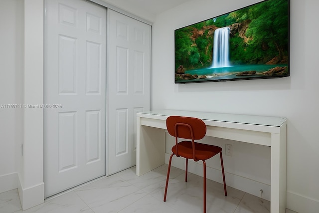 2966 NW 26th St, Miami, FL 33142 - home office featuring light marble finish floors, built in desk, and baseboards