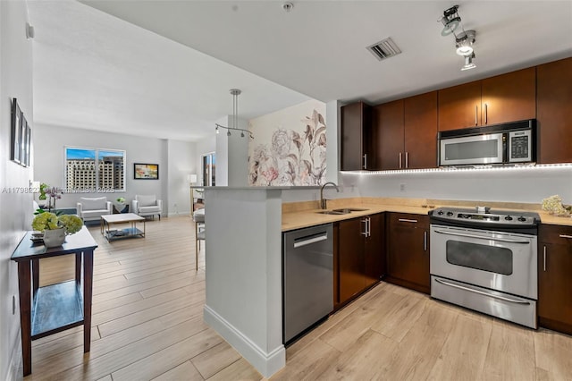 10 Aragon Ave Unit 1107, Coral Gables, FL 33134 - kitchen with appliances with stainless steel finishes, a sink, open floor plan, and light wood-style floors