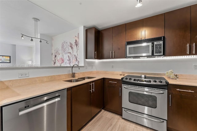 10 Aragon Ave Unit 1107, Coral Gables, FL 33134 - kitchen with appliances with stainless steel finishes, a sink, light countertops, dark brown cabinets, and light wood finished floors