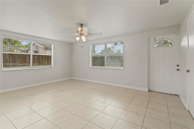 unfurnished room featuring a ceiling fan, light tile patterned flooring, and baseboards