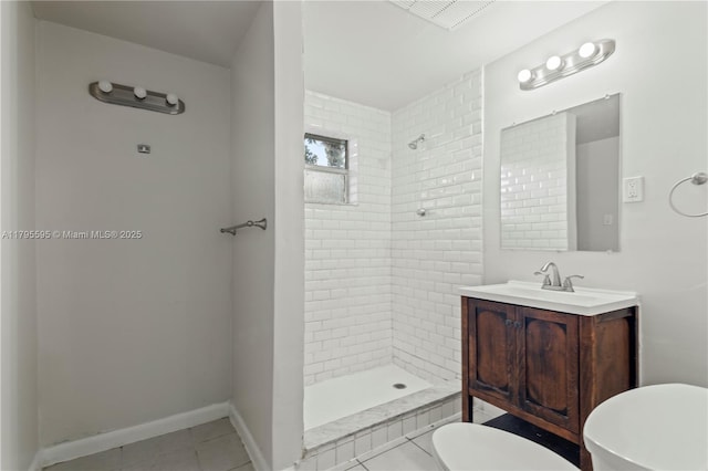 full bathroom with toilet, a tile shower, tile patterned floors, vanity, and baseboards