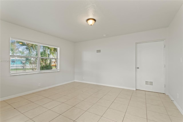 unfurnished room with baseboards and light tile patterned flooring