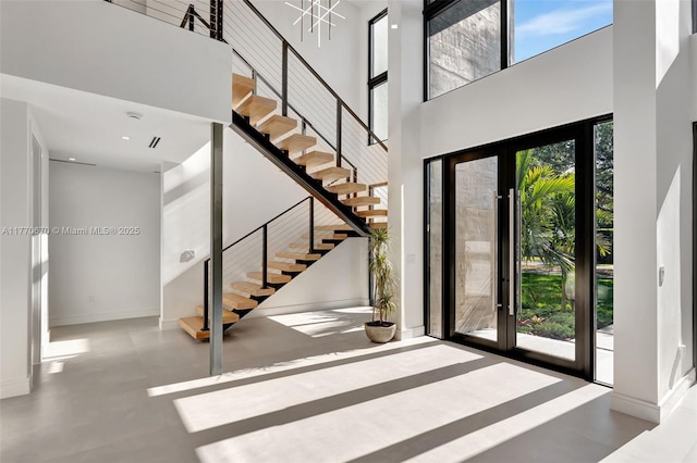 11143 NE 8th Ave, Biscayne Park, FL 33161 - foyer entrance with a towering ceiling, healthy amount of natural light, stairway, and baseboards