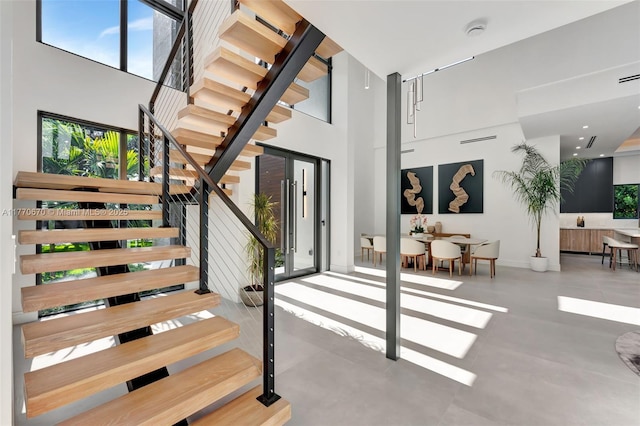 11143 NE 8th Ave, Biscayne Park, FL 33161 - staircase featuring healthy amount of natural light, a high ceiling, and baseboards