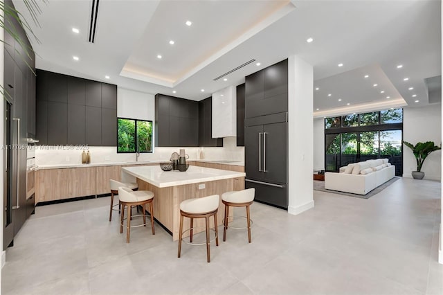 11143 NE 8th Ave, Biscayne Park, FL 33161 - kitchen featuring modern cabinets, a tray ceiling, a kitchen breakfast bar, and recessed lighting