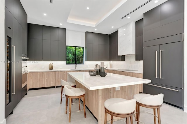 11143 NE 8th Ave, Biscayne Park, FL 33161 - kitchen featuring modern cabinets, paneled built in fridge, a breakfast bar, backsplash, and recessed lighting