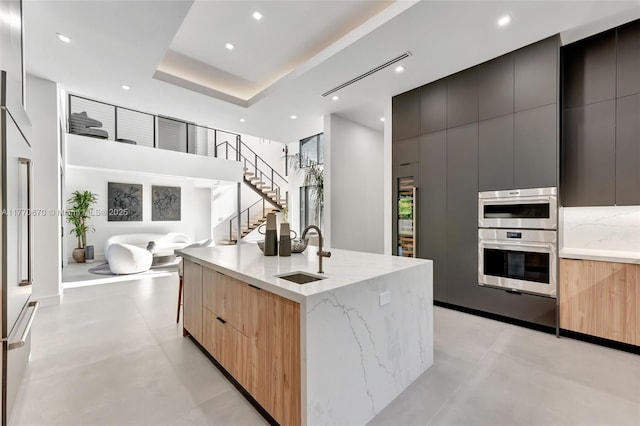 11143 NE 8th Ave, Biscayne Park, FL 33161 - kitchen featuring modern cabinets, light brown cabinets, light stone counters, recessed lighting, and a high ceiling
