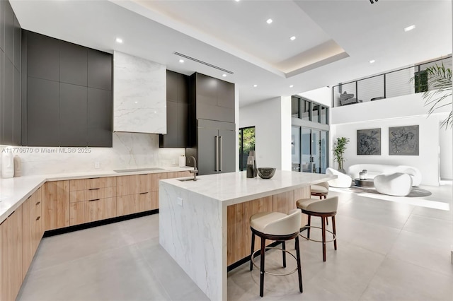 11143 NE 8th Ave, Biscayne Park, FL 33161 - kitchen featuring modern cabinets, light brown cabinetry, a high ceiling, a kitchen breakfast bar, and a spacious island