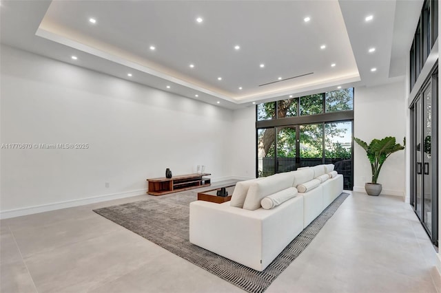 11143 NE 8th Ave, Biscayne Park, FL 33161 - living room with a tray ceiling, finished concrete flooring, recessed lighting, baseboards, and a high ceiling