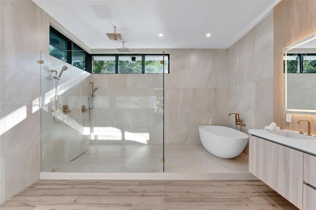 11143 NE 8th Ave, Biscayne Park, FL 33161 - full bath with tile walls, a tile shower, a freestanding tub, vanity, and wood finished floors