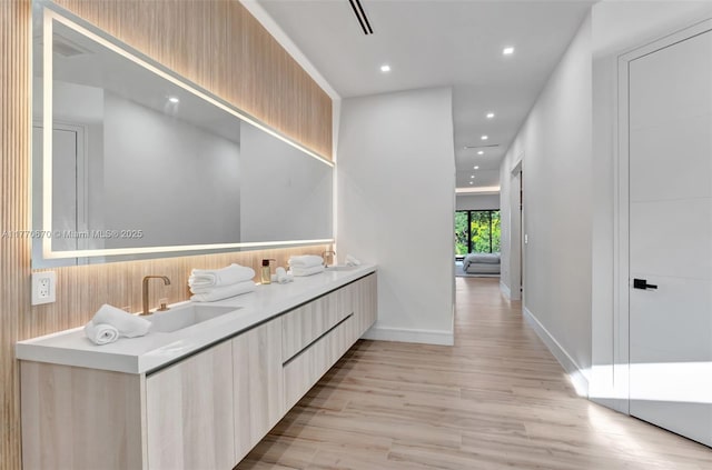 11143 NE 8th Ave, Biscayne Park, FL 33161 - bathroom featuring wood finished floors, recessed lighting, double vanity, and baseboards