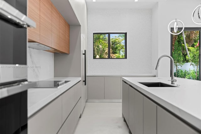 1320 NE 16th Ave, Fort Lauderdale, FL 33304 - kitchen with a sink, light countertops, black electric stovetop, modern cabinets, and gray cabinets