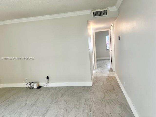 9920 NW 68th Pl Unit 103, Tamarac, FL 33321 - laundry area with crown molding, baseboards, and light marble finish flooring