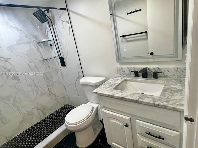 9920 NW 68th Pl Unit 103, Tamarac, FL 33321 - full bath featuring toilet, vanity, and a marble finish shower