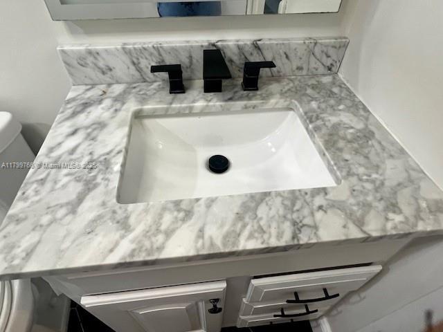 9920 NW 68th Pl Unit 103, Tamarac, FL 33321 - bathroom view of tasteful backsplash, toilet, and vanity