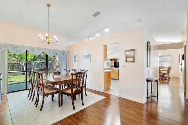 15827 Waverly Mnr, Davie, FL 33331 - dining area featuring light wood-style floors, a chandelier, baseboards, lofted ceiling, and rail lighting