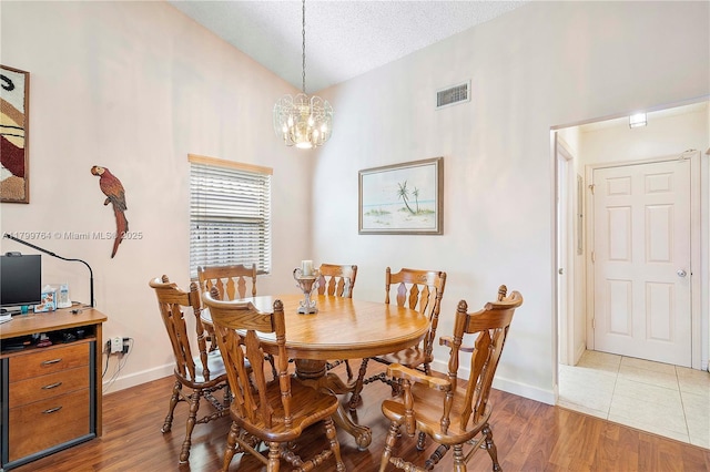 15827 Waverly Mnr, Davie, FL 33331 - dining area featuring vaulted ceiling, a chandelier, baseboards, light wood-style flooring, and a textured ceiling