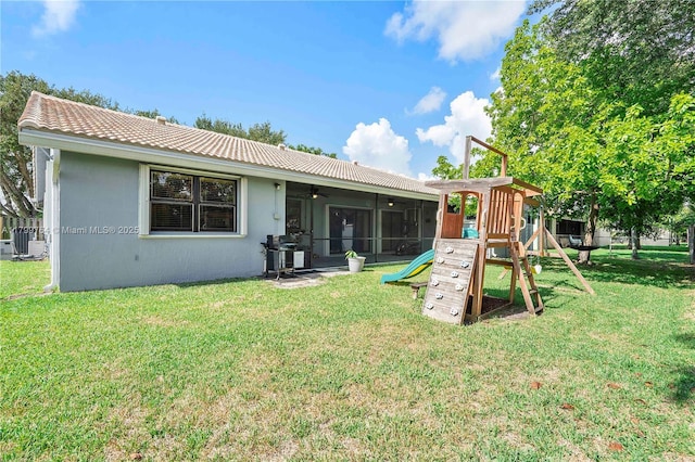 15827 Waverly Mnr, Davie, FL 33331 - rear view of house with a playground, a lawn, a ceiling fan, a tiled roof, and stucco siding