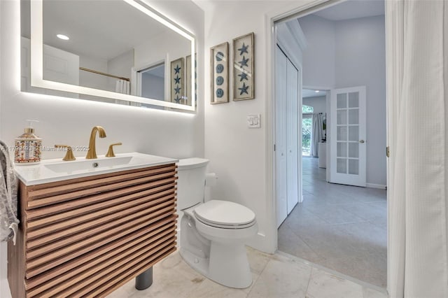5020 Ibis Ct, Coconut Creek, FL 33073 - full bathroom featuring toilet, baseboards, vanity, tile patterned floors, and french doors