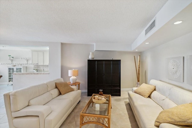 100 Golden Isles Dr Unit 1105, Hallandale Beach, FL 33009 - living area featuring light tile patterned flooring, a textured ceiling, recessed lighting, and baseboards