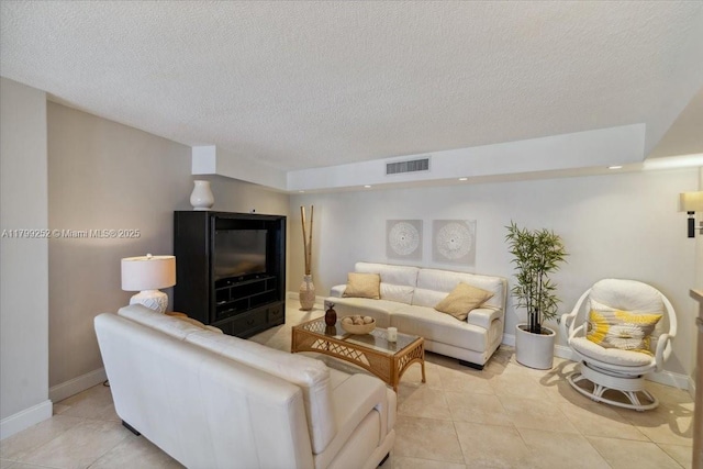 100 Golden Isles Dr Unit 1105, Hallandale Beach, FL 33009 - living room with light tile patterned flooring, a textured ceiling, and baseboards