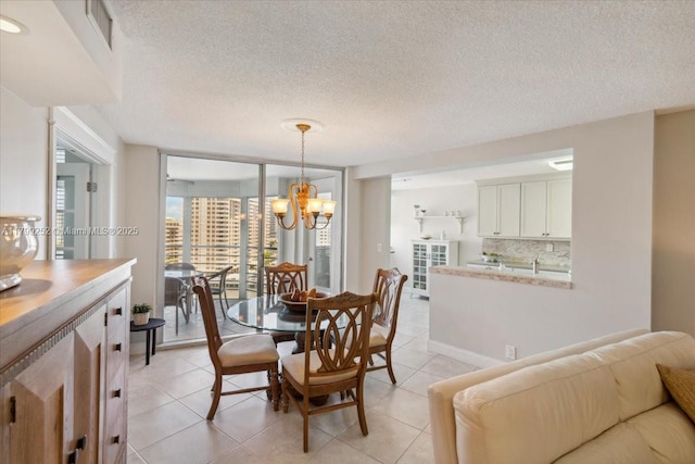 100 Golden Isles Dr Unit 1105, Hallandale Beach, FL 33009 - dining area featuring a chandelier, light tile patterned floors, and a textured ceiling