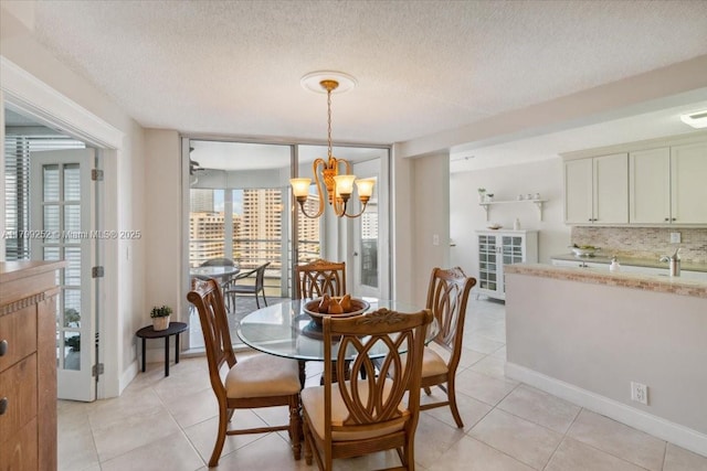 100 Golden Isles Dr Unit 1105, Hallandale Beach, FL 33009 - dining area with a chandelier, light tile patterned flooring, a textured ceiling, and baseboards
