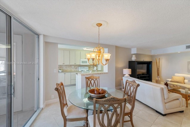 100 Golden Isles Dr Unit 1105, Hallandale Beach, FL 33009 - dining room with a chandelier, a textured ceiling, light tile patterned flooring, and baseboards