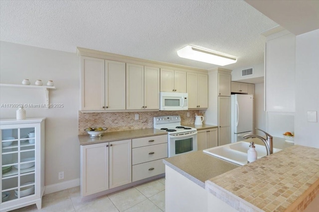 100 Golden Isles Dr Unit 1105, Hallandale Beach, FL 33009 - kitchen with white appliances, a sink, decorative backsplash, a textured ceiling, and light countertops