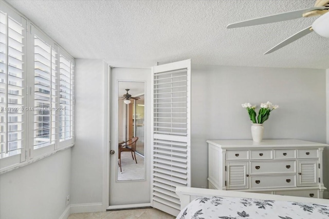 100 Golden Isles Dr Unit 1105, Hallandale Beach, FL 33009 - bedroom with multiple windows, a textured ceiling, ceiling fan, and baseboards