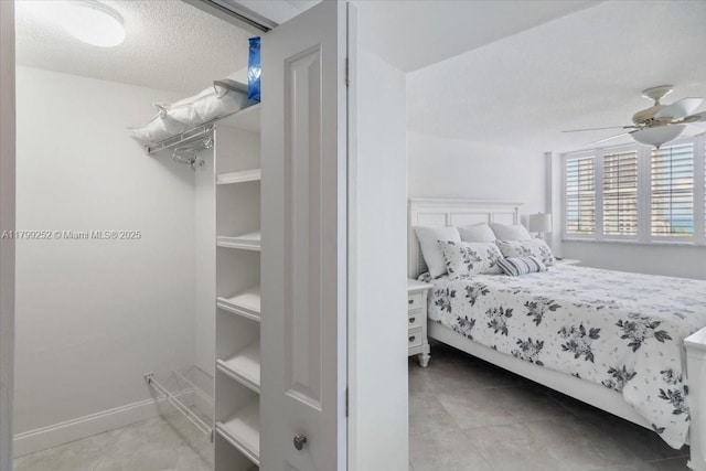 100 Golden Isles Dr Unit 1105, Hallandale Beach, FL 33009 - bedroom featuring light tile patterned floors, a textured ceiling, and a ceiling fan