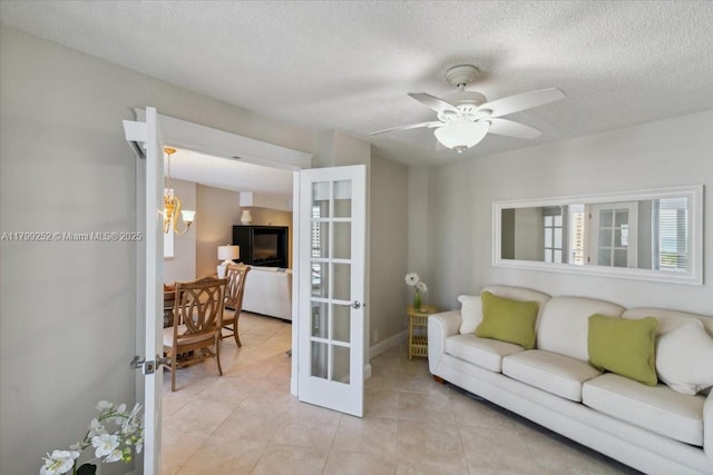 100 Golden Isles Dr Unit 1105, Hallandale Beach, FL 33009 - living room with light tile patterned flooring, a textured ceiling, ceiling fan, french doors, and baseboards