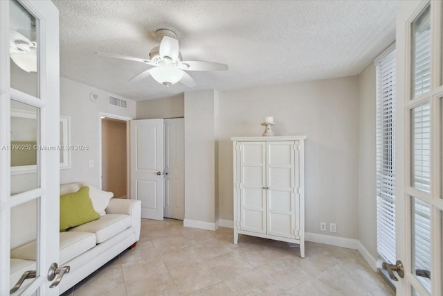 100 Golden Isles Dr Unit 1105, Hallandale Beach, FL 33009 - living area with a textured ceiling, a ceiling fan, french doors, light tile patterned flooring, and baseboards