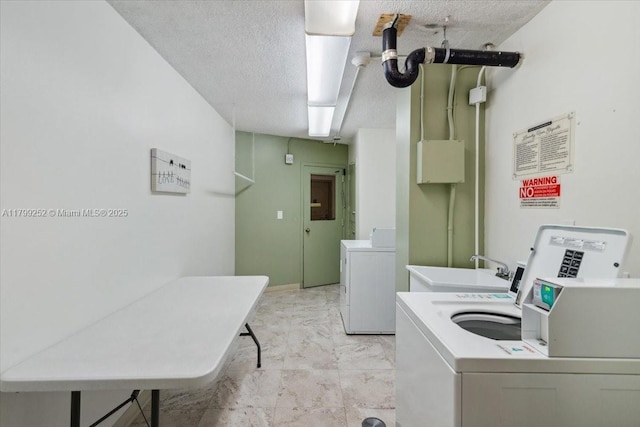 100 Golden Isles Dr Unit 1105, Hallandale Beach, FL 33009 - shared laundry featuring light marble finish floors, washer and clothes dryer, and a textured ceiling