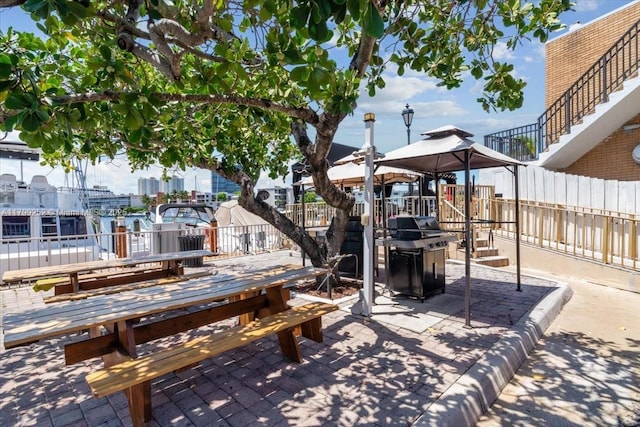 100 Golden Isles Dr Unit 1105, Hallandale Beach, FL 33009 - view of patio with area for grilling, fence, outdoor dining space, and a gazebo