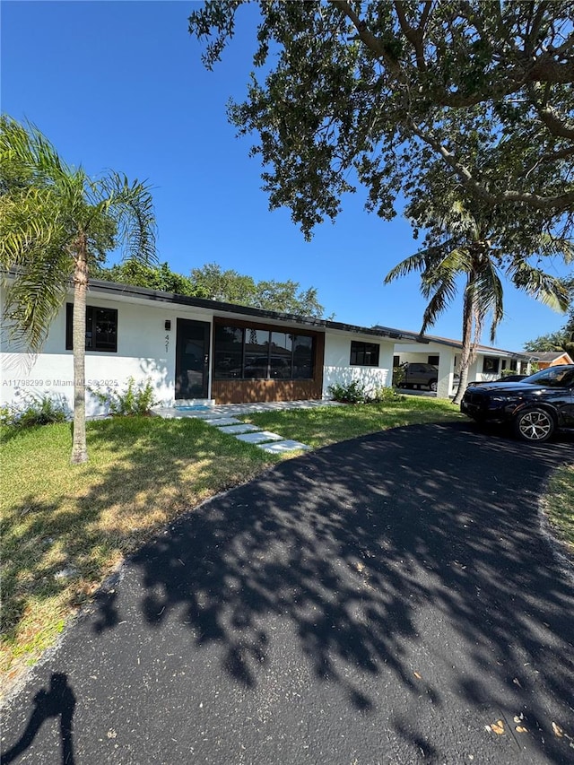 421 SW 11th Ave, Hallandale Beach, FL 33009 - view of front facade with a front yard, stucco siding, and a sunroom