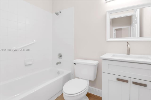 bathroom with toilet, vanity, shower / washtub combination, and baseboards