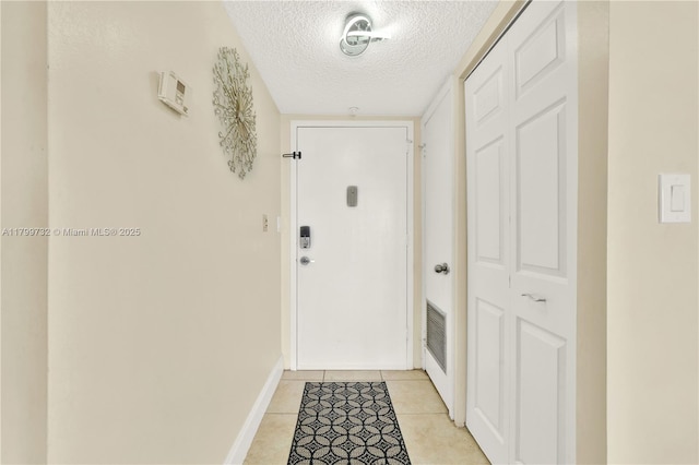 2750 NE 183rd St Unit 504, Aventura, FL 33160 - doorway with a textured ceiling, baseboards, and light tile patterned floors
