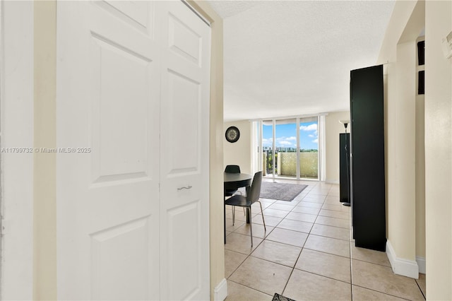 2750 NE 183rd St Unit 504, Aventura, FL 33160 - corridor with expansive windows, light tile patterned floors, baseboards, and a textured ceiling