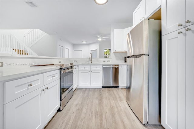 16818 SW 1st Mnr, Pembroke Pines, FL 33027 - kitchen featuring stainless steel appliances, light wood-style flooring, white cabinets, a sink, and light countertops