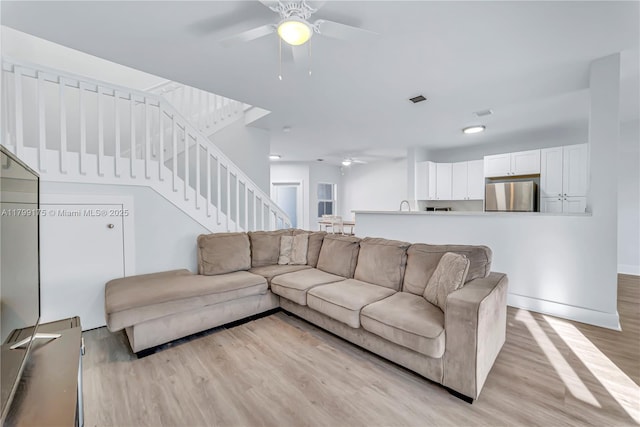 16818 SW 1st Mnr, Pembroke Pines, FL 33027 - living room with ceiling fan, light wood-style floors, stairway, and baseboards