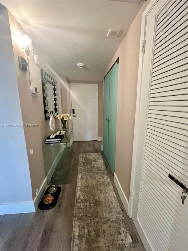 hall with wood finished floors and baseboards