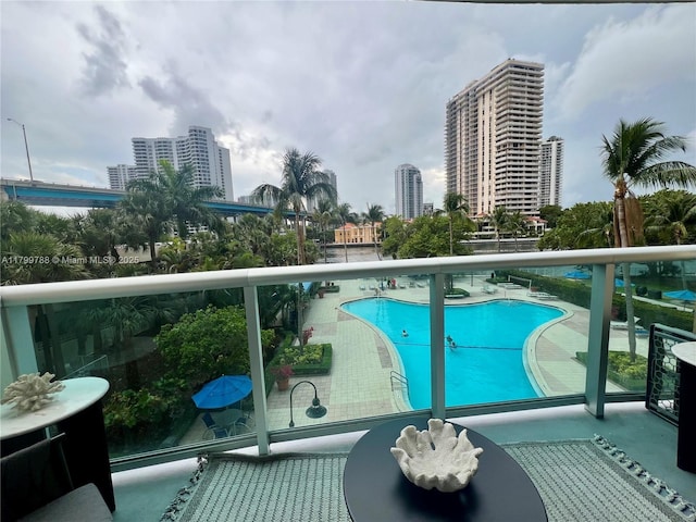 balcony featuring view of pool area and a city view