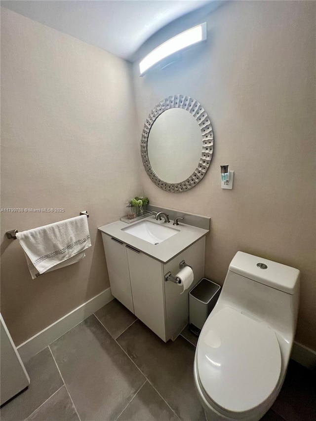 half bathroom with toilet, vanity, tile patterned flooring, and baseboards