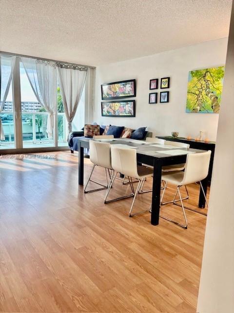dining space with a textured ceiling, light wood-style floors, and breakfast area