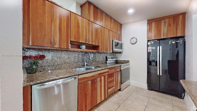 5010 SW 111th Ave, Miami, FL 33165 - kitchen featuring stainless steel appliances, a sink, decorative backsplash, light tile patterned flooring, and dark stone countertops